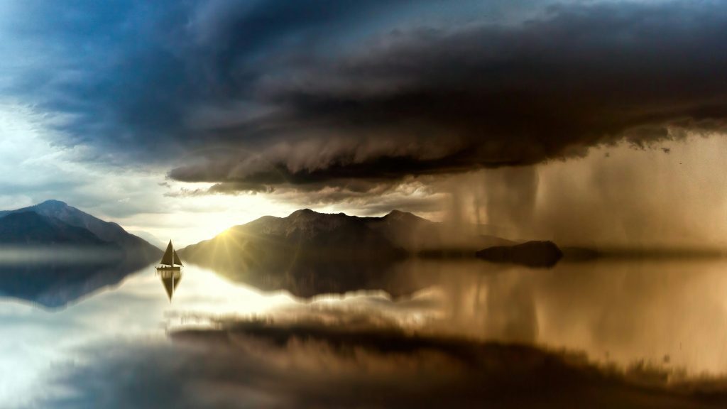A majestic scene of a sailboat on a calm lake with dramatic storm clouds and sunset reflections.